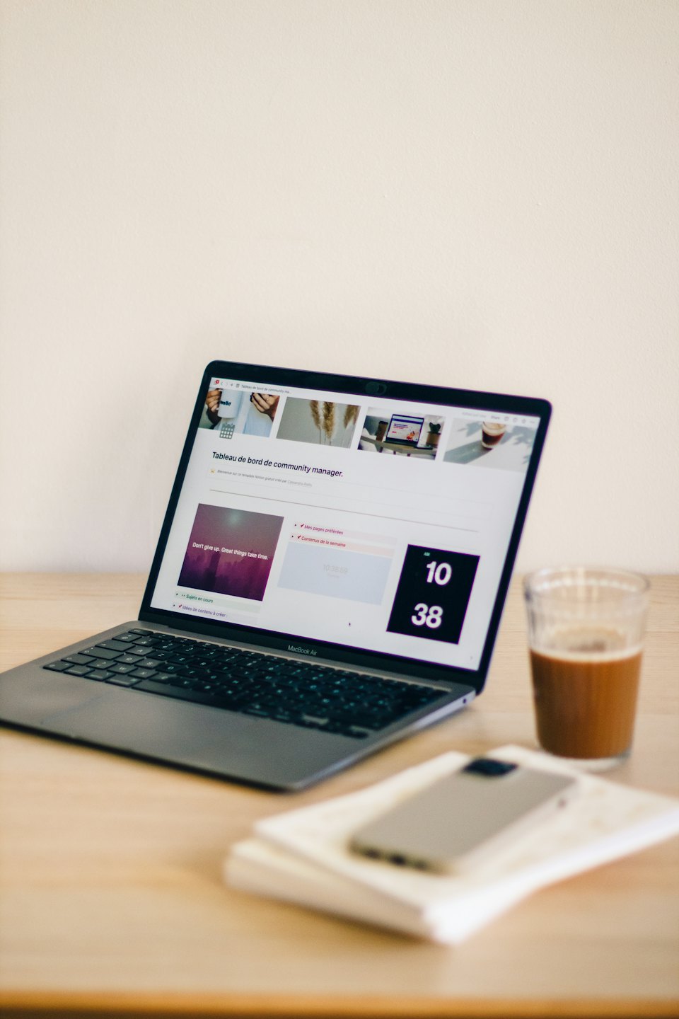 Laptop con dashboard su una scrivania di legno con caffè freddo.